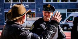 SFPD officer smiling at man wearing cowboy hat